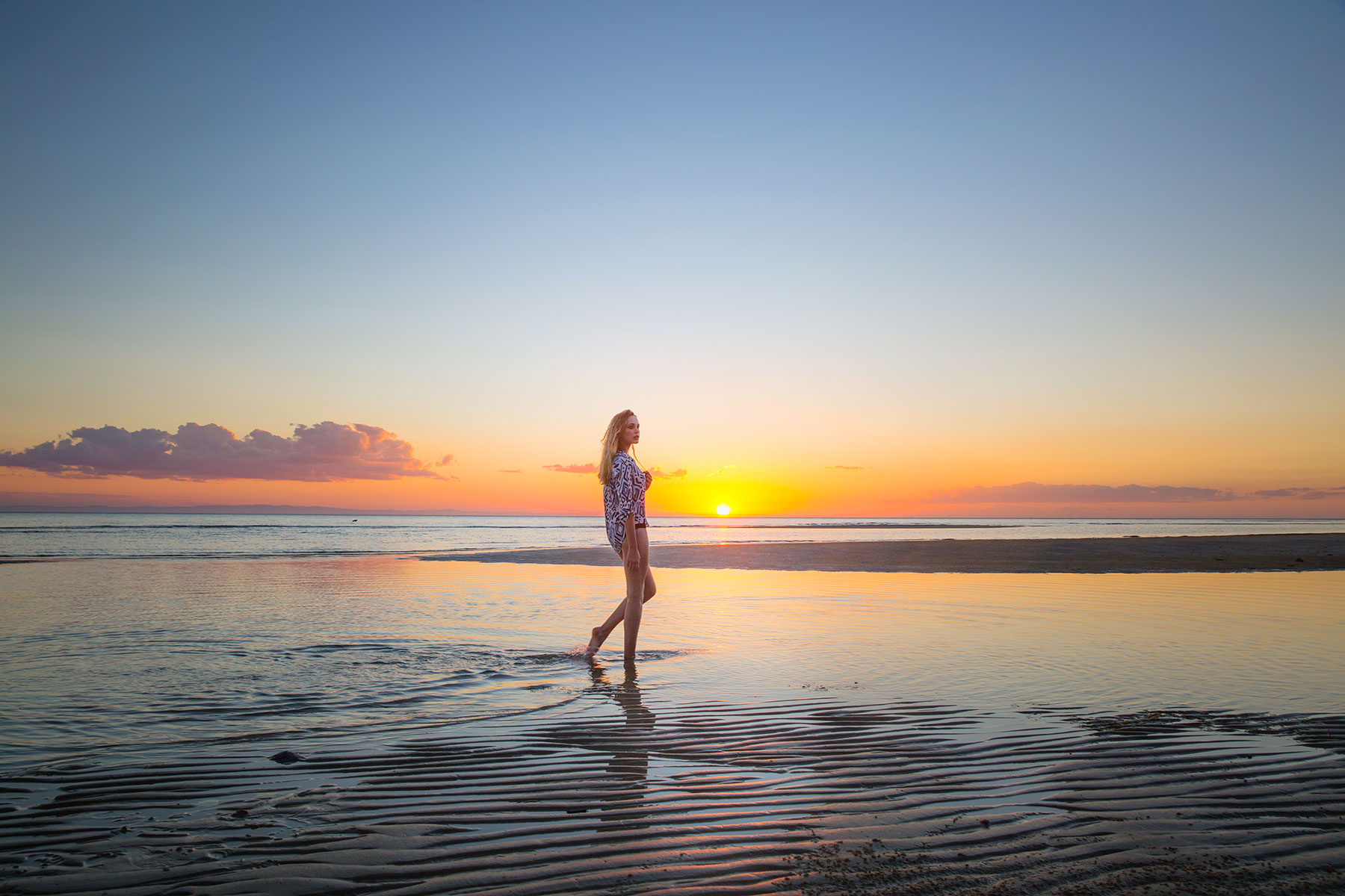 Young model walking on Australian beach at sunset 