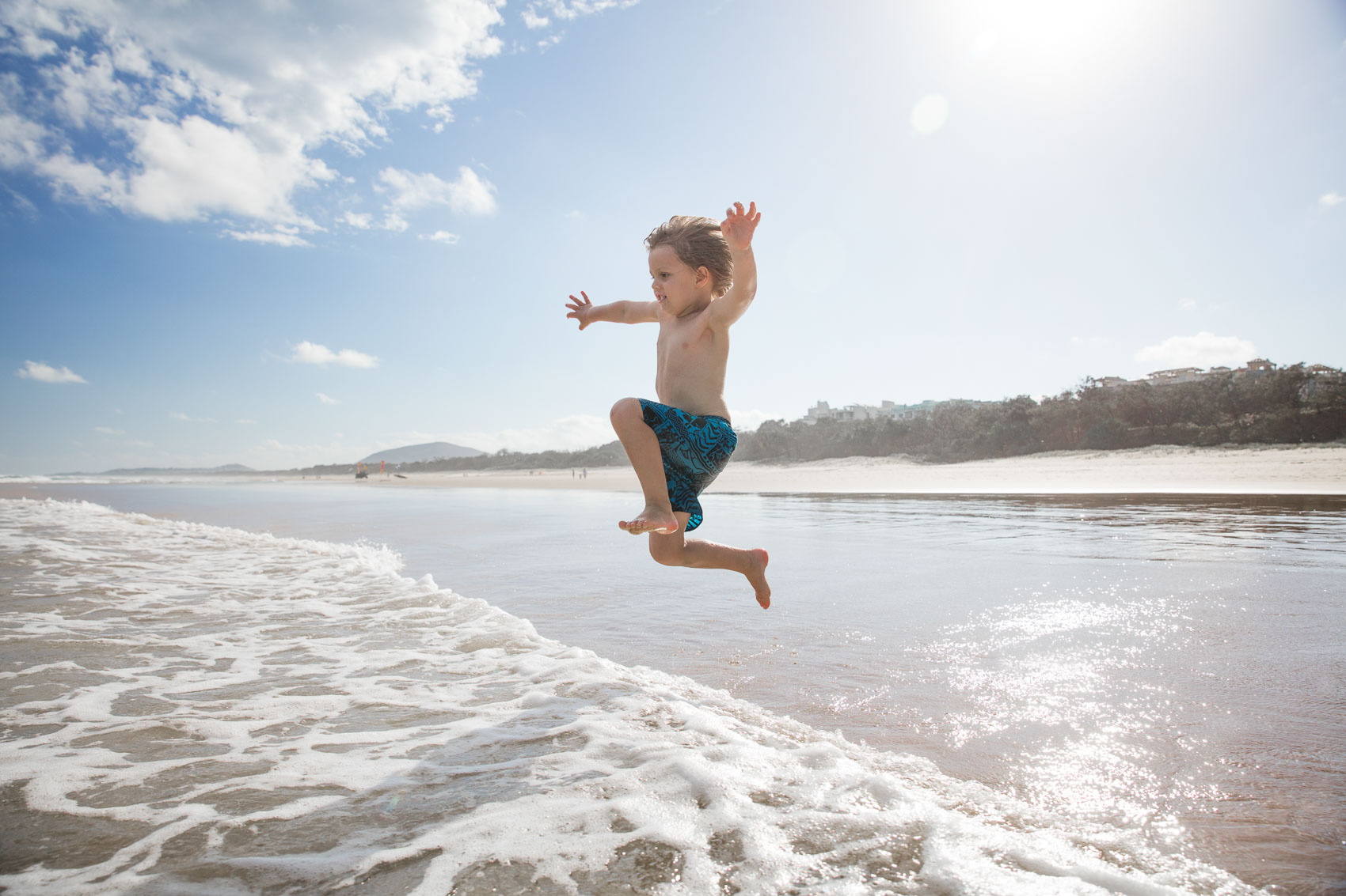 Young boy jumping into waves at Australian beach